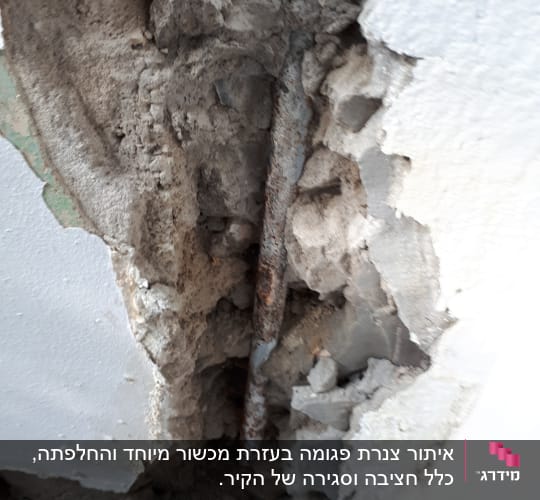 צינור חלוד בקיר שבור עם בטון חשוף